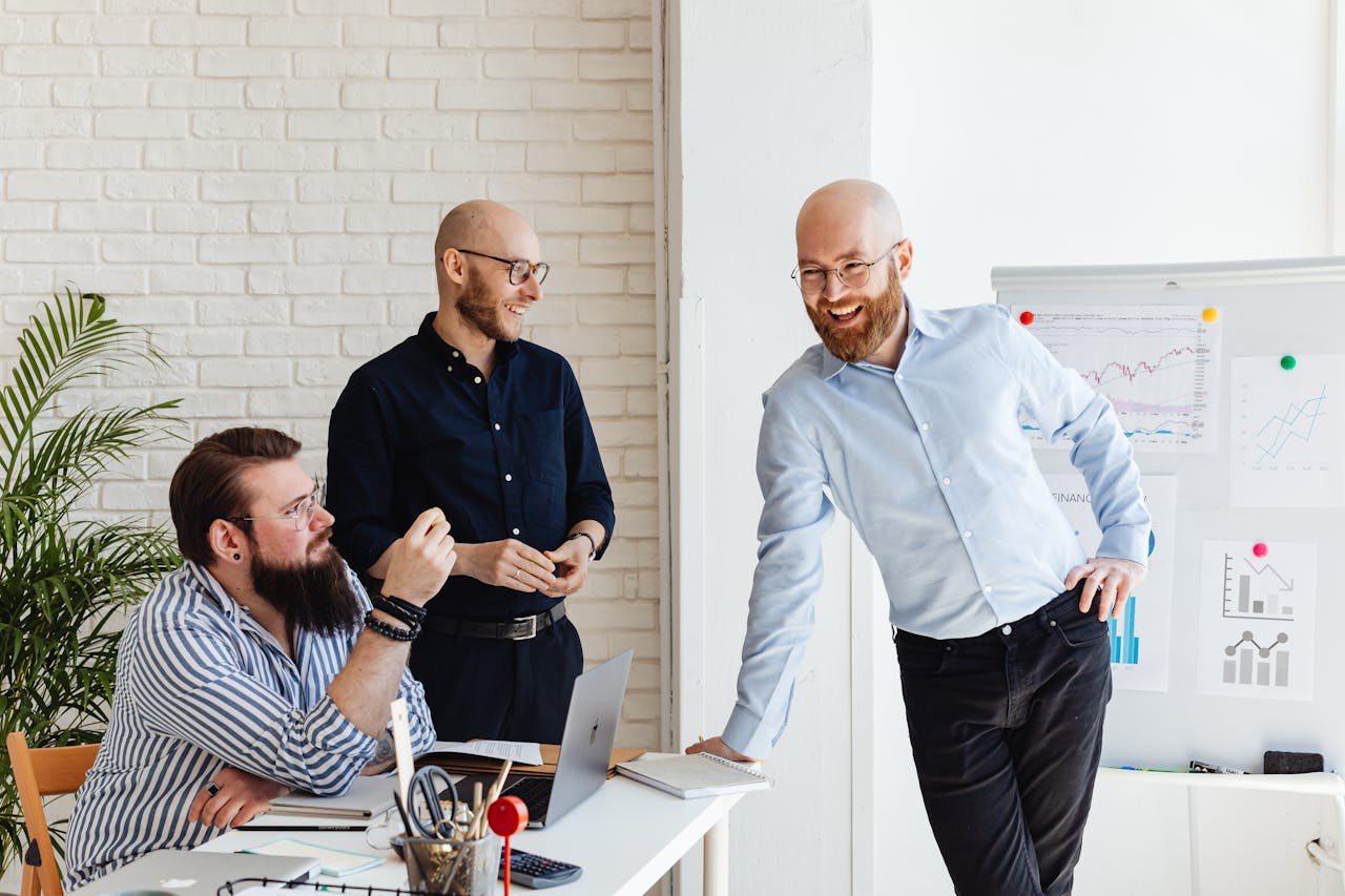 Three male colleagues engaged in a collaborative business meeting in a modern office.